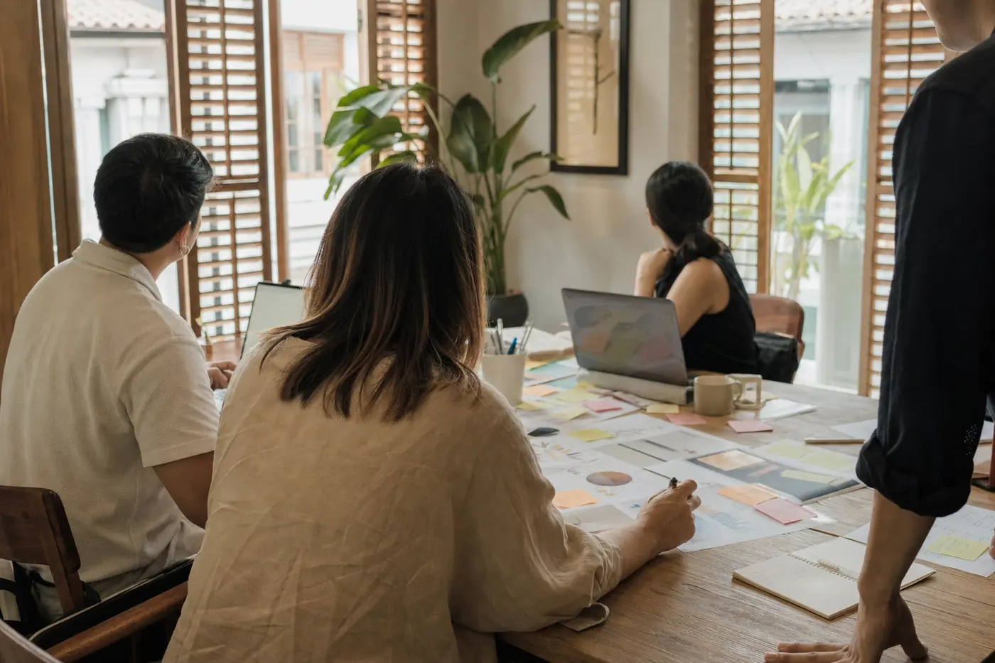 Members of the Polus Marketing Troy team reviewing printed campaign dashboards around a table in a Singapore shophouse office